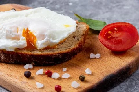 Eco lunch with a boiled egg on bread with seeds on a wooden tray Stock Photos