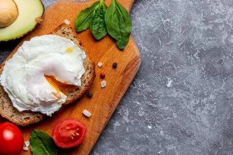 Eco lunch with a poached egg on bread with seeds on a wooden tray Stock Photos
