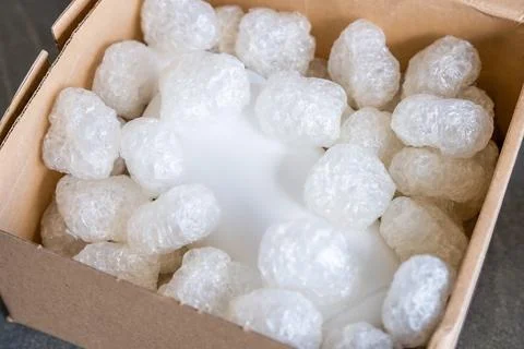 Eco packaging of parcels and white biodegradable filler. Box is filled with a Stock Photos