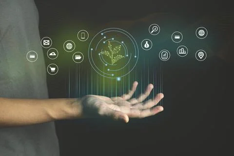 Eco Technology Hand with glowing low poly green sprout on dark blue backgroun Stock Photos