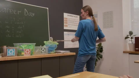 Eco Volunteer Demonstrating Litter Picker Tool in School Stock Footage 328325913