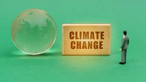 Ecological concept. On the green surface is a globe and a figurine of a man w Stock Photos