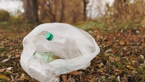Ecological concept stop plastic. White bag with plastic bottles on the grass Stock Footage 120872066