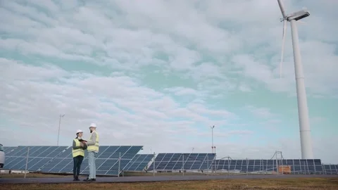 Ecological engineers use digital tablet and talk at the solar panel field Video stock 171969056
