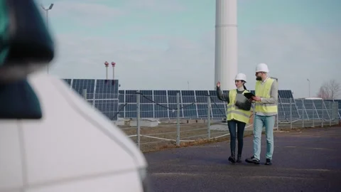 Ecological engineers walk at the solar panel field, shot from far Video stock 171969339
