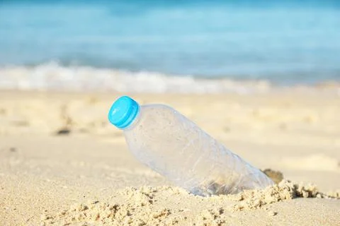 Ecological problem, used plastic bottle on sea shore Stock Photos