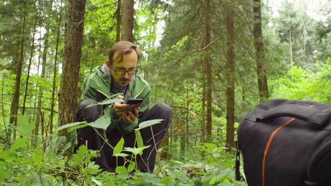 The ecologist in a forest with smart phone Stock Footage 93716692