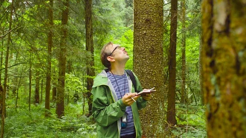 The ecologist in a forest writing in notebook. Stockbeeldmateriaal 92432887