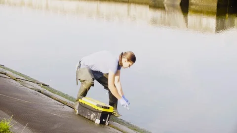 Ecologist getting samples of water in city river Stock Footage 95391658