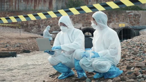 Ecologist sampling water from the river with test tube and save data to laptop Stock Footage 243322242