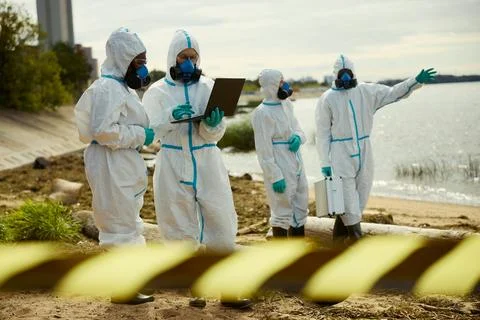 Ecologists in Hazmat Suits Analyzing Water Pollution Data Stock Photos