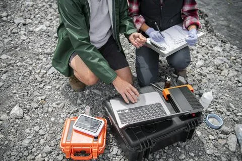 Ecologists taking water quality samples with equipment Foto stock