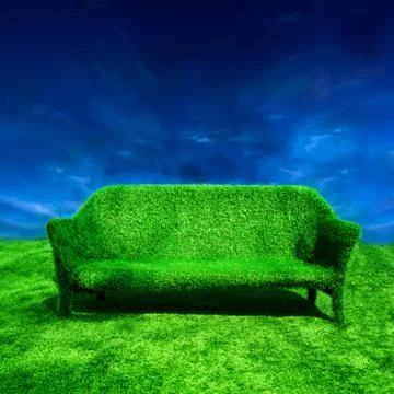 Ecology concept background. grassy sofa standing at green grass over blue sky Stock Photos