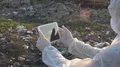 Ecology worker specialist with mask with tablet on the landfill  4k or 4k+ Resolution