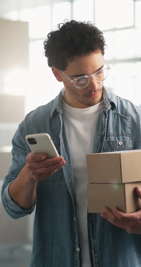 Ecommerce, man and boxes in small business with phone, website and typing Stock Footage 347268678