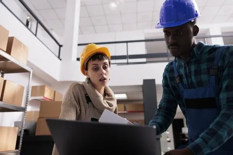 Ecommerce storehouse operatives checking online order for parcel preparation Foto stock