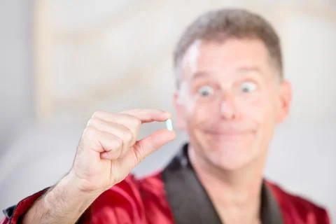 Ecstatic Man with Blue Pill to Combat Erectile Dysfunction Stock Photos
