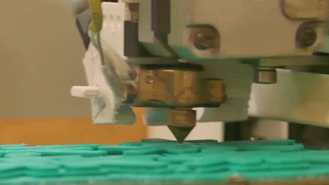 ECU of the head of a 3D printer in operation printing a green item Stock Footage 75345927