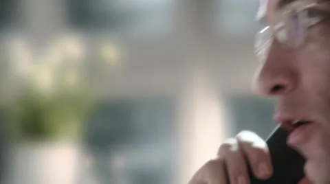 ECU, SELECTIVE FOCUS, Profile of businessman talking on landline phone Stock Footage 10701631