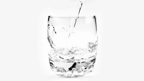 ECU TD SLO MO Shot of Water being poured into Glass against White Background Stock Footage 265845877