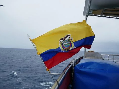 Ecuador flag open with wind currents on back of boat on the ocean Stock Photos