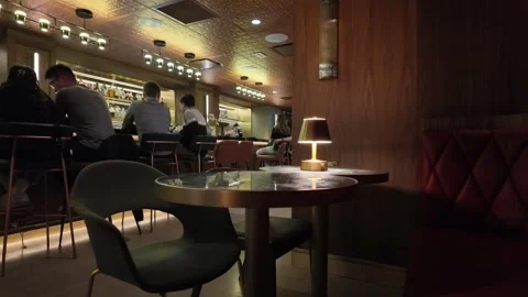 ED: London, ON, CAD 5/21/2025: Empty Table in Speakeasy With Distant Chatter at Stock Footage 332071860