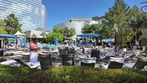 ED: LV, NV, US 8/25/25: Vacationers Relax by the Pool at Luxury Resort in Las Stock Footage 319028997