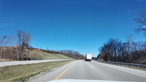 ED: Toledo, OH, USA 3/25/2025: Trucks Driving Along the Highway in Ohio on a Stock Footage 332382553