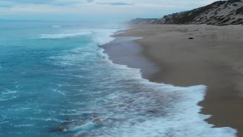 ED288_Down low shot, distant coastline with waves crashing underneath Stock Footage 116366305