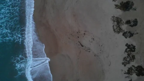 ED295_Ariel shot looking down at a beach with turquoise waves crashing. rocks. Stock Footage 116371689