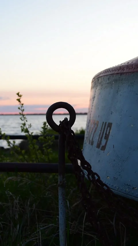 The edge of a boat lying on the shore. Grass sways nearby. Stock Footage 242334657