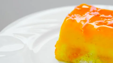 Edge of cake with orange jam, rotates on white plate Stock Footage 54227704