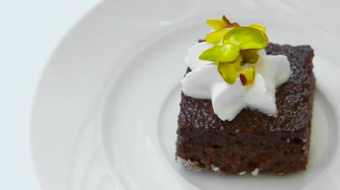 Edge of chocolate cake with decoration rotates on white plate, top view Stock Footage 54230424