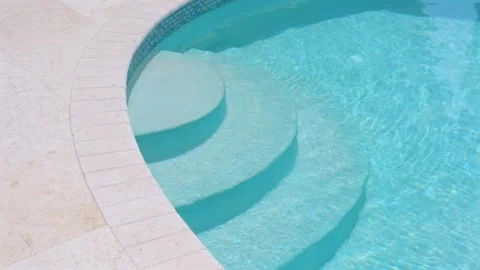 Edge of inground swimming pool with three step staircase and blue mosaic Видео 247702338
