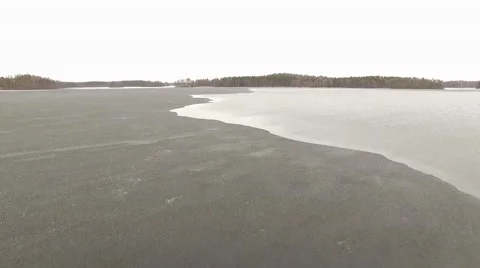 Edge of melting ice at a lake in springtime, aerial overflight shot Stock Footage 68024406