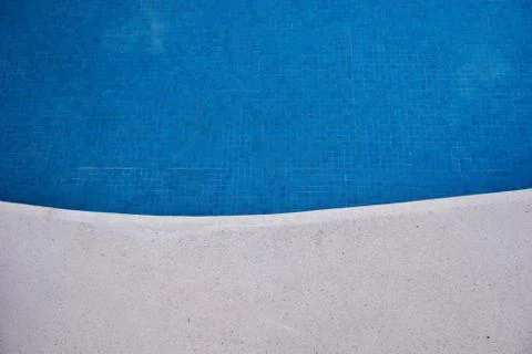 At the edge of the pool. Blue tile at the bottom of the pool and gray around. Stock Photos