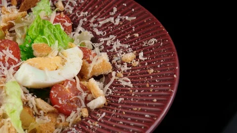 Edge of a red plate with Chicken Caesar salad, served in Restaurant, loop Stock Footage 91031754