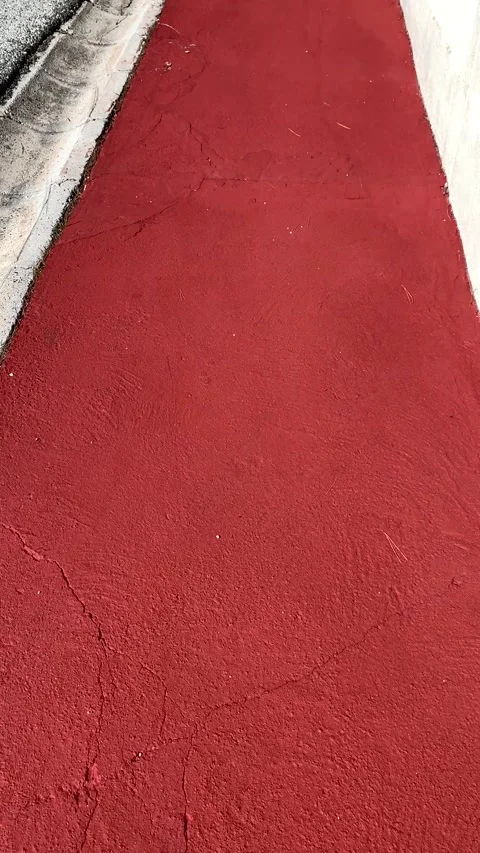 Edge of red Spanish sidewalk with a stone drainage channel Stock Footage 308306307