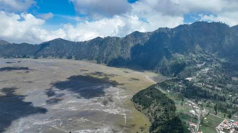 On the edge of the sand plain, fields and villages cling to the caldera wall Foto stock