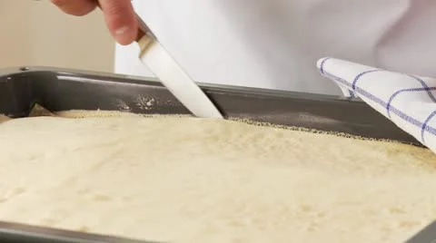 The edge of sponge cake being lossened from a baking tray Stock Footage 24638960