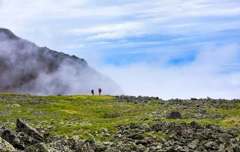 Edge world. Two men standing on edge of hanging valley Stock Photos