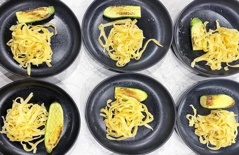  Edible pattern from black plates with spaghetti. On the plates are pasta ... Stock Photos