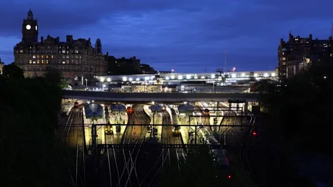 Edinburgh illuminated central train station with train arrival at blue hour Stock Footage 310465556