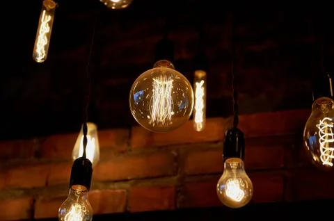 Edison light bulb hanging on a long wire. Cozy warm yellow light.Retro Stock Photos