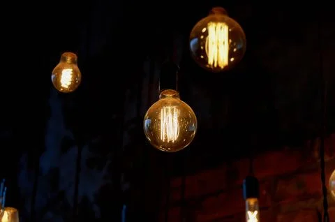 Edison light bulb hanging on a long wire. Cozy warm yellow light.Retro Stock Photos