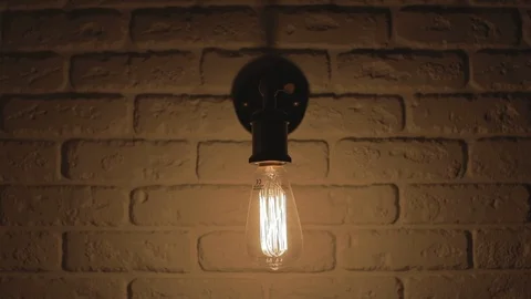 Edison Light Bulb Is Turning On And Off In Front Of A Brick Wall. Loft Design. Stock Footage 125447115
