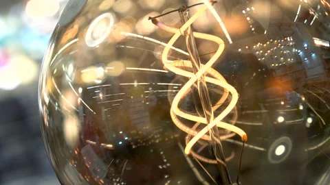 Edisson lamp spin closeup. Yellow tungsten filament macro 4K. Glare lamp insole Stock Footage 98333014