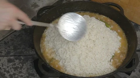 EDIT Spreading rice on cauldron and filling it with water Stock Footage 7753016