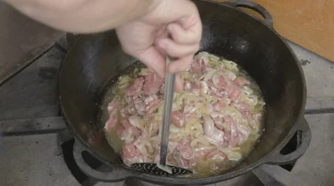 EDIT Turning with slotted spoon slices of pork and onions Stock Footage 7752947
