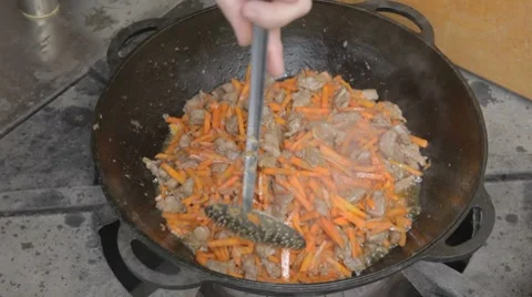EDIT Turning with slotted spoon slices of pork and carrots Stock-Footage 7753002
